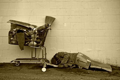 homeless man asleep on cardboard.