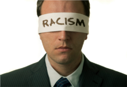 Blindfolded man with "racism" text on the blindfold