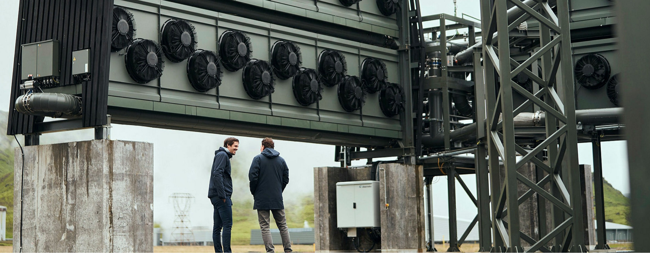 two men stand at the Orca Plant in Iceland