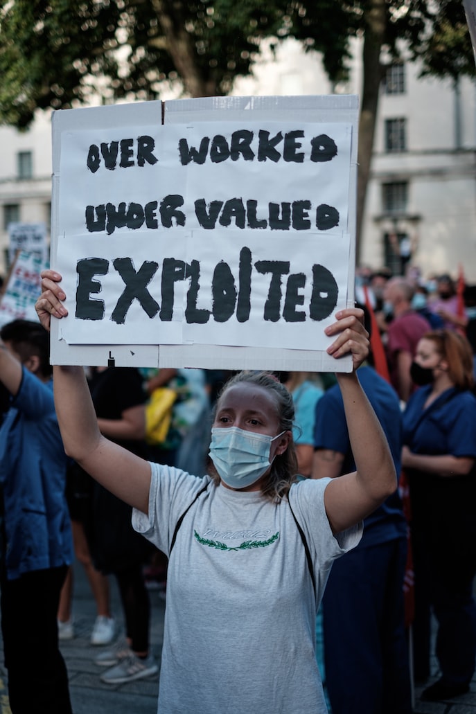 A protester in London opposing poor wages (https://unsplash.com/photos/E77RYPFWyBA)